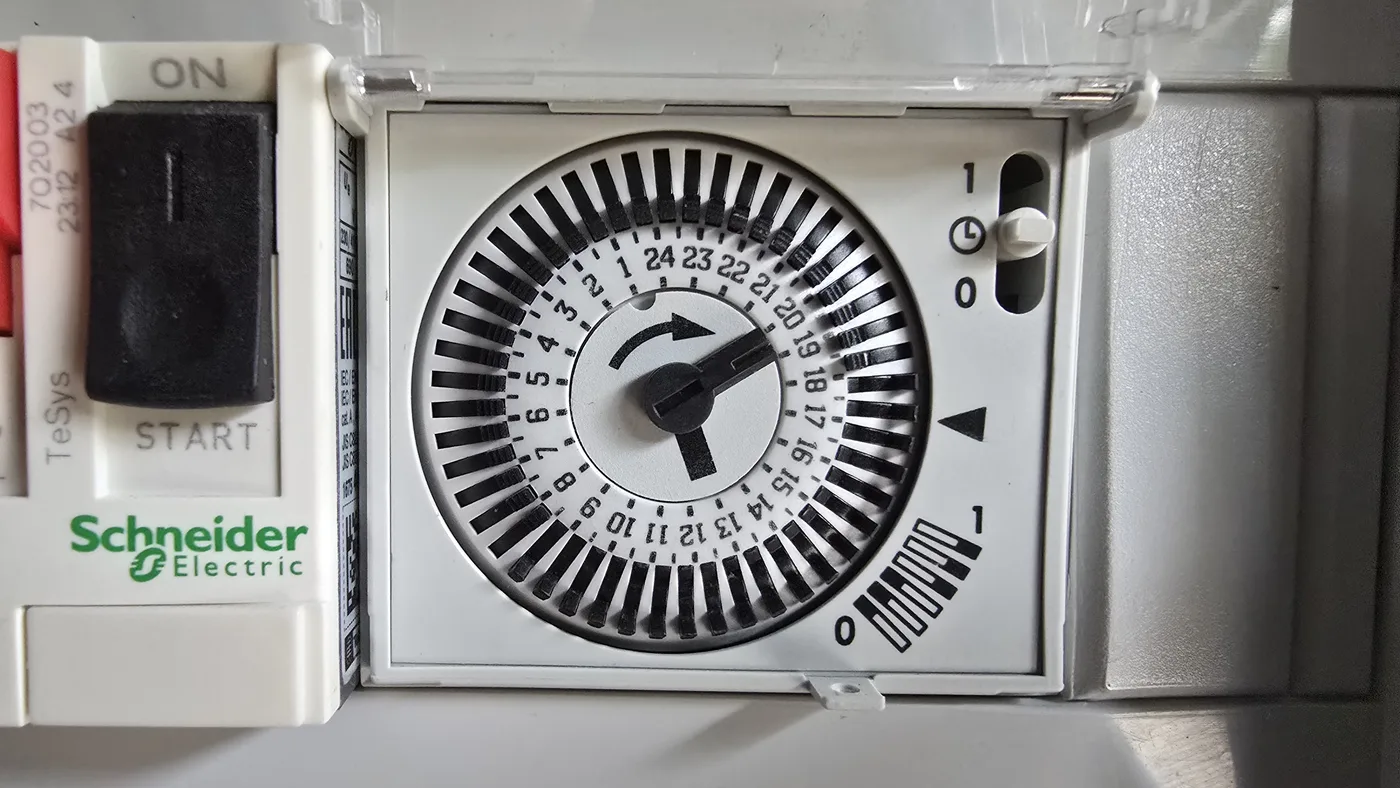 Horloge mécanique Schneider de programmation de la filtration de piscine, avec ses plages horaires sur 24 heures