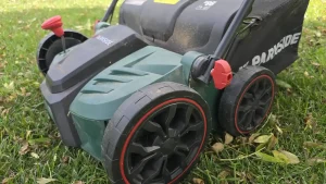 Scarificateur électrique Parkside PELV 1800 C3 posé sur une pelouse parsemée de feuilles mortes
