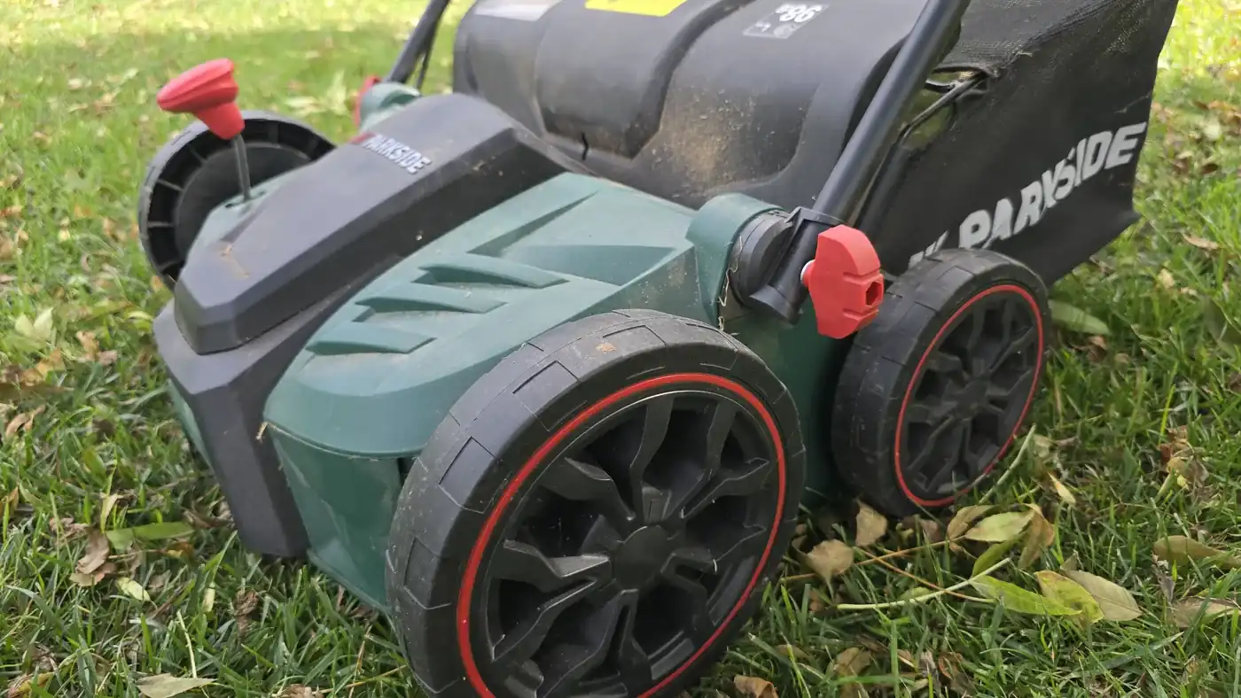 Scarificateur électrique Parkside PELV 1800 C3 posé sur une pelouse parsemée de feuilles mortes